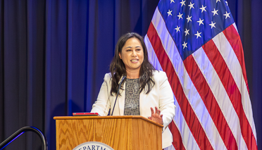 asian female speaker behind podium